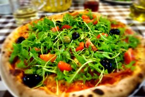 Pizza mit Rohschinken, Rucola & Oliven